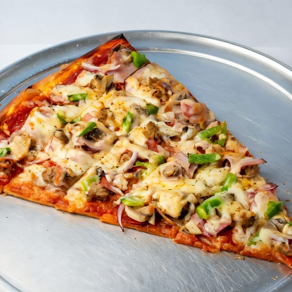 A large slice of Pascali's Pizza Corner pizza with various toppings on a metal tray.