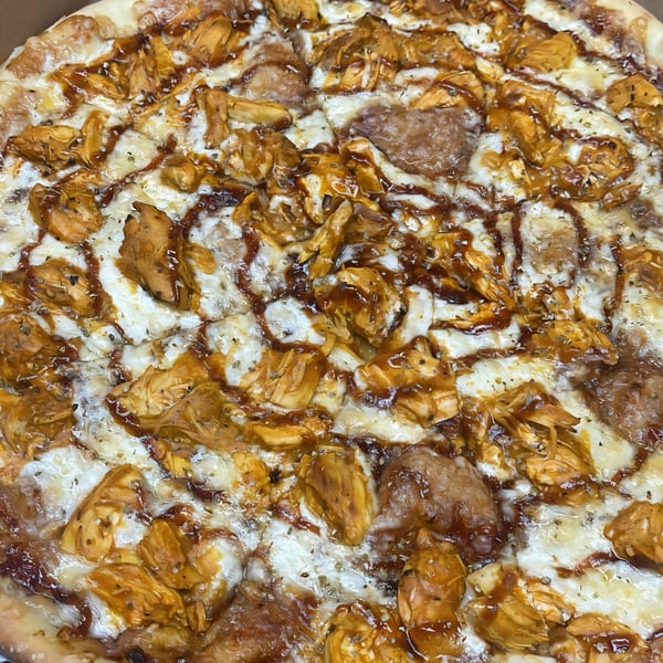 Close-up of a Pascali's Pizza Corner BBQ chicken pizza, topped with melted cheese and sauce.